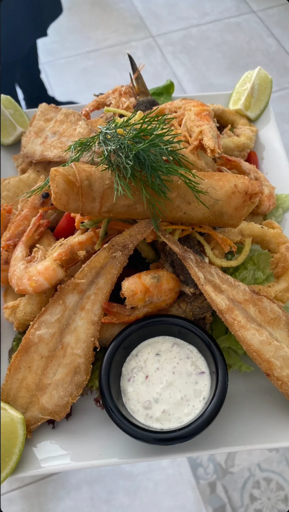 Friture de poissons et crevettes garnie d'aneth, citron vert et sauce blanche
